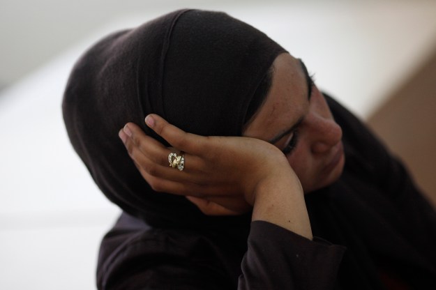 A Syrian refugee woman rests inside a Spanish Red Cross office before being transferred to a reception centre in Spain, upon their arrival from Melilla at Malaga port